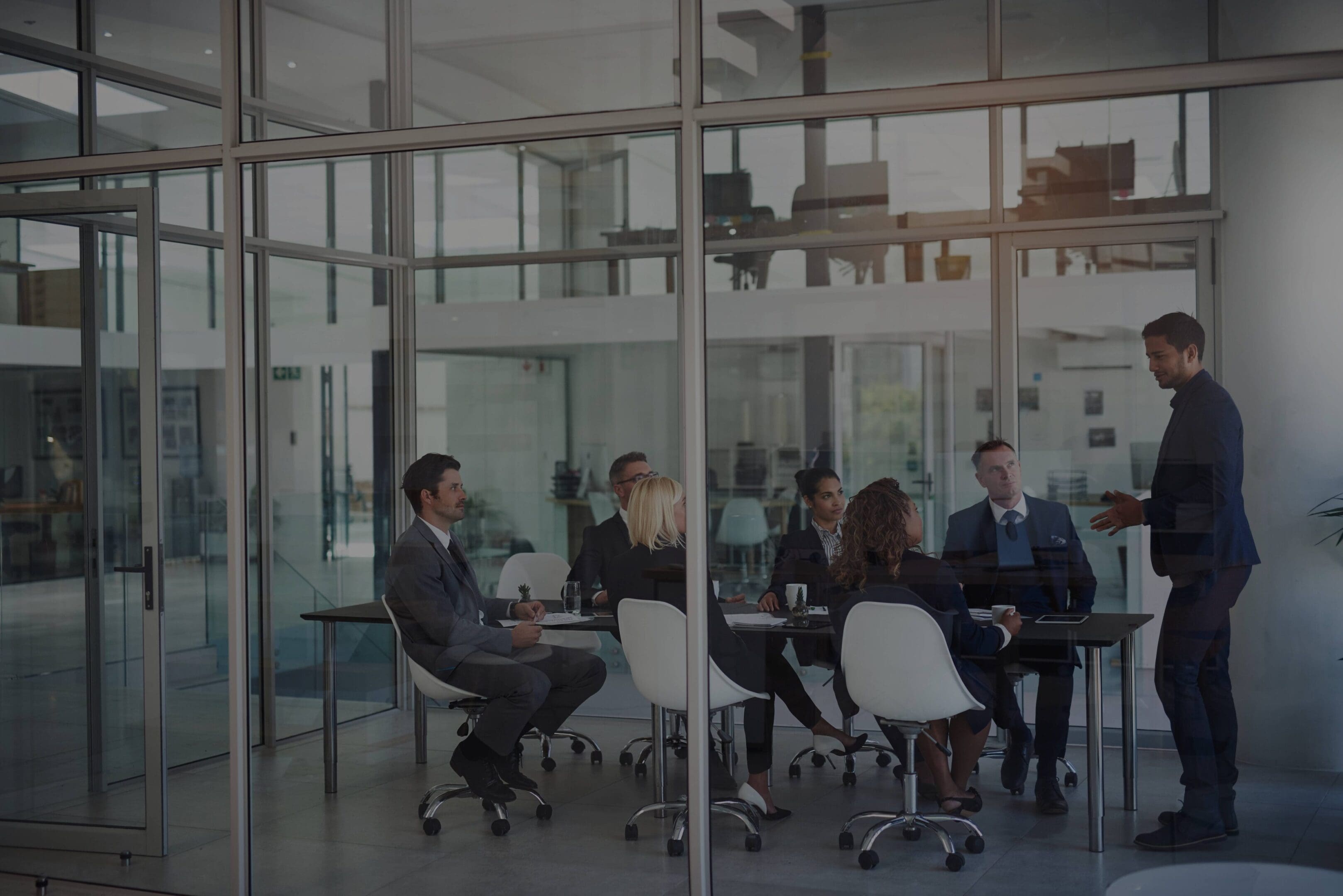 Business meeting with diverse team in modern glass office.